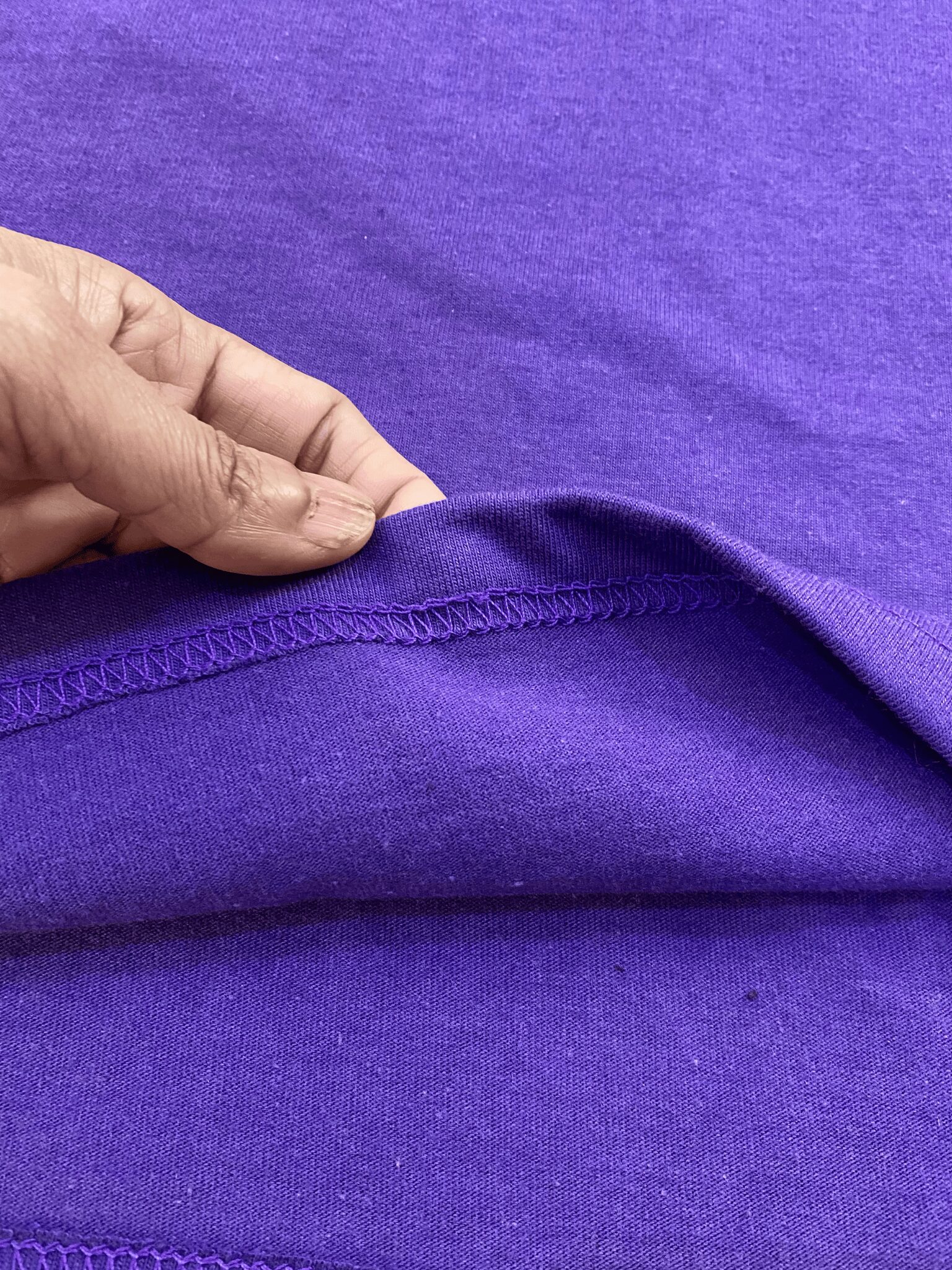 Closeup of inside stitching and seam finishing of t-shirt showing durability and clean construction