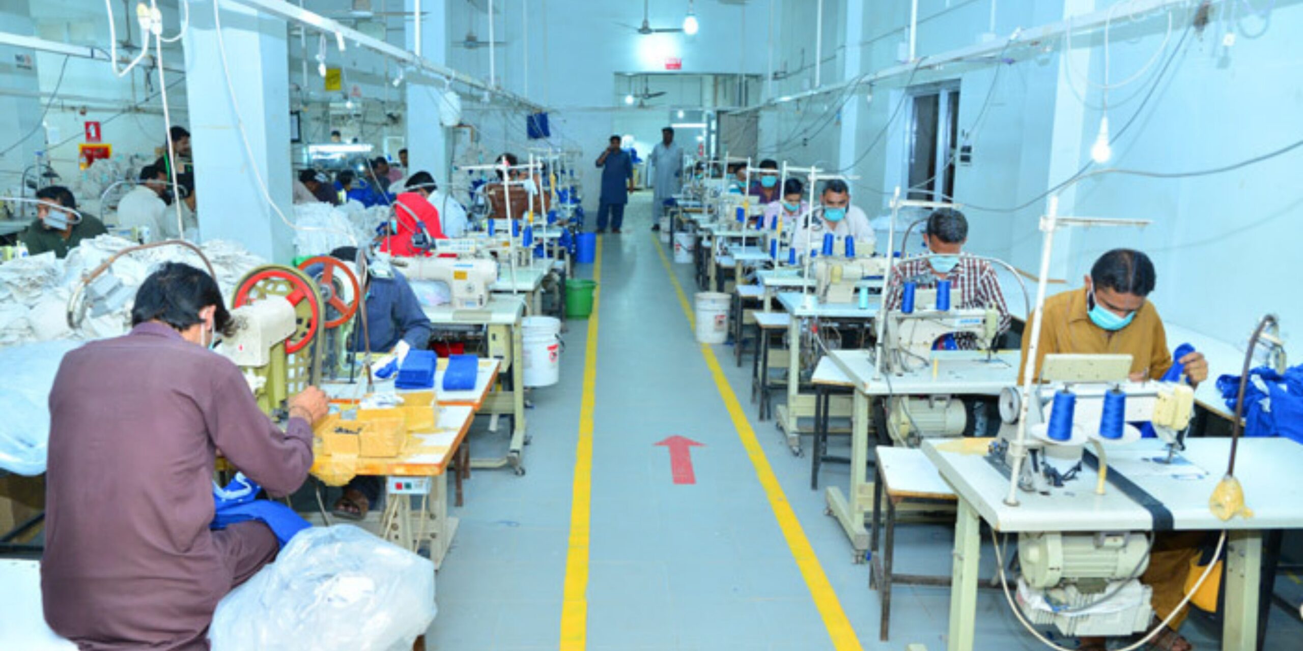 Garment manufacturing unit with workers producing industrial workwear